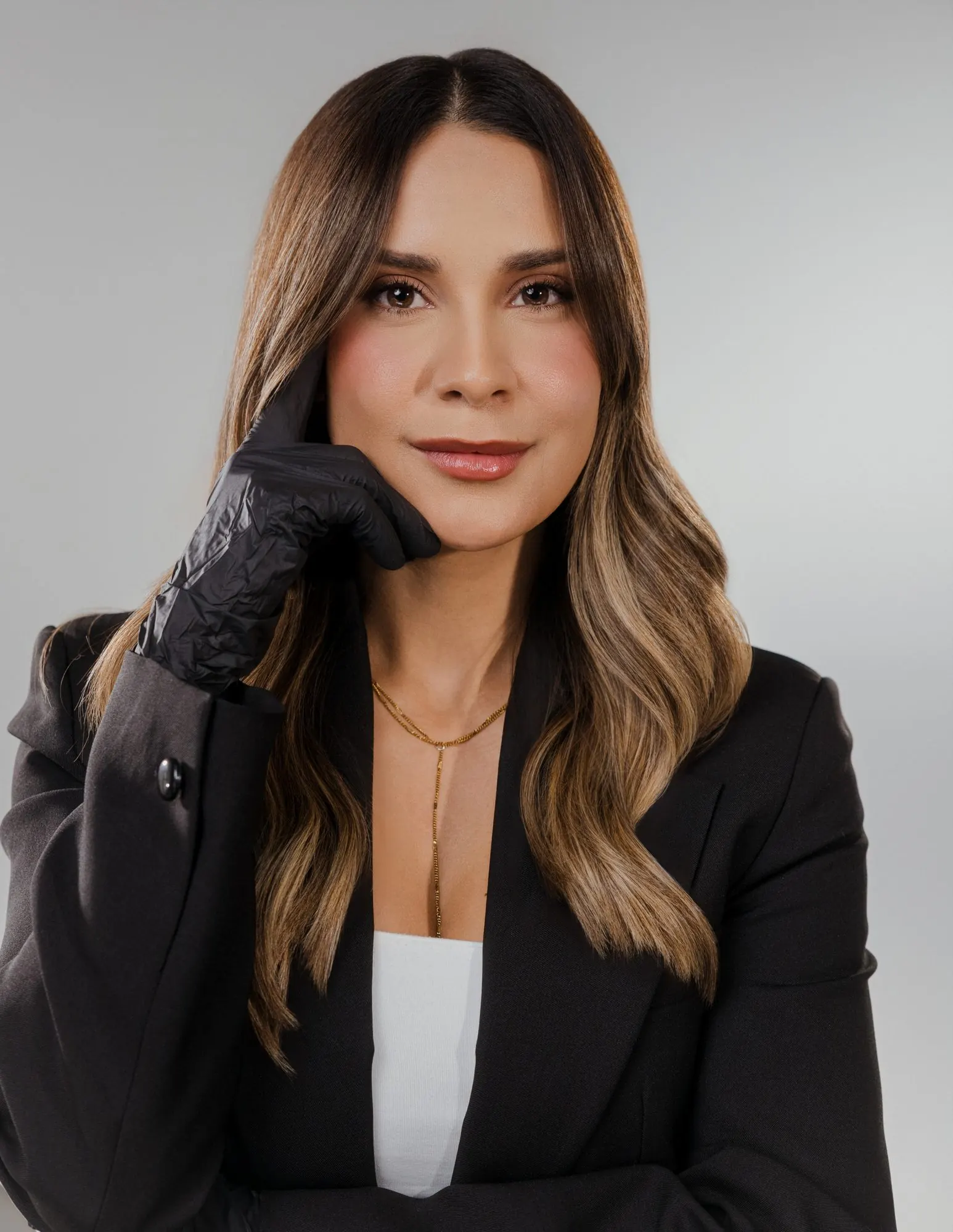 Nicole Torres, especialista en Naturale Brows, con guantes negros y blazer negro